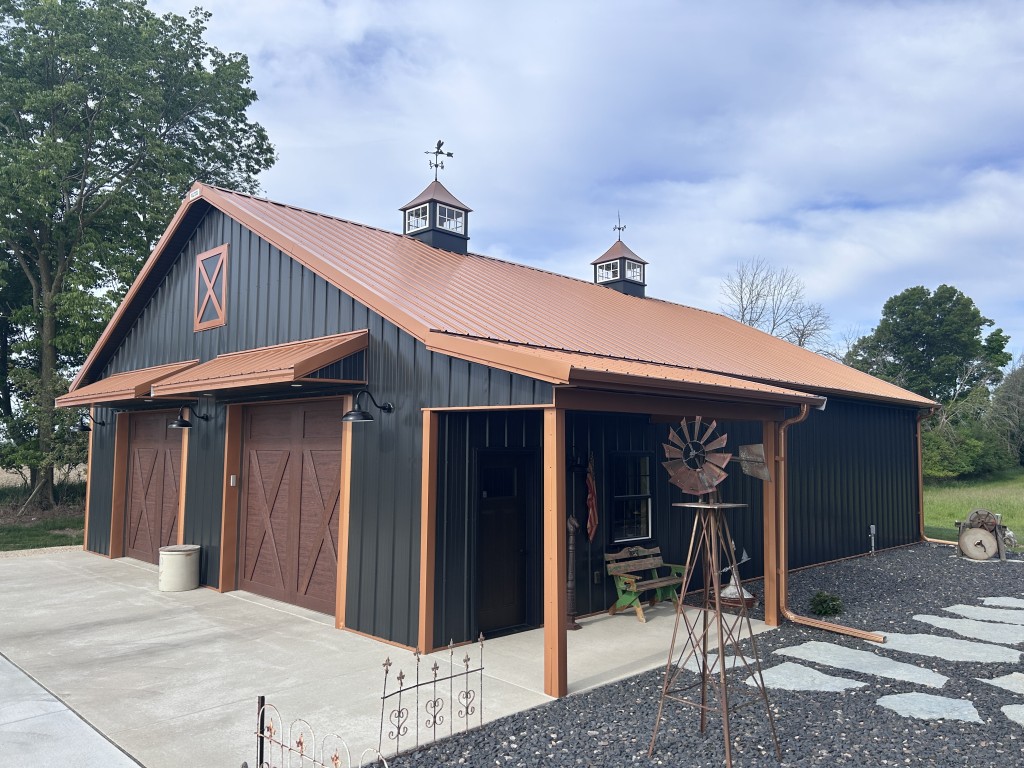 Side Porch on 36×50 Black Metal Garage Side view of 36x50 black metal garage with copper roof, copper trim, side porch, cupolas, and Clopay garage doors by Walters Buildings