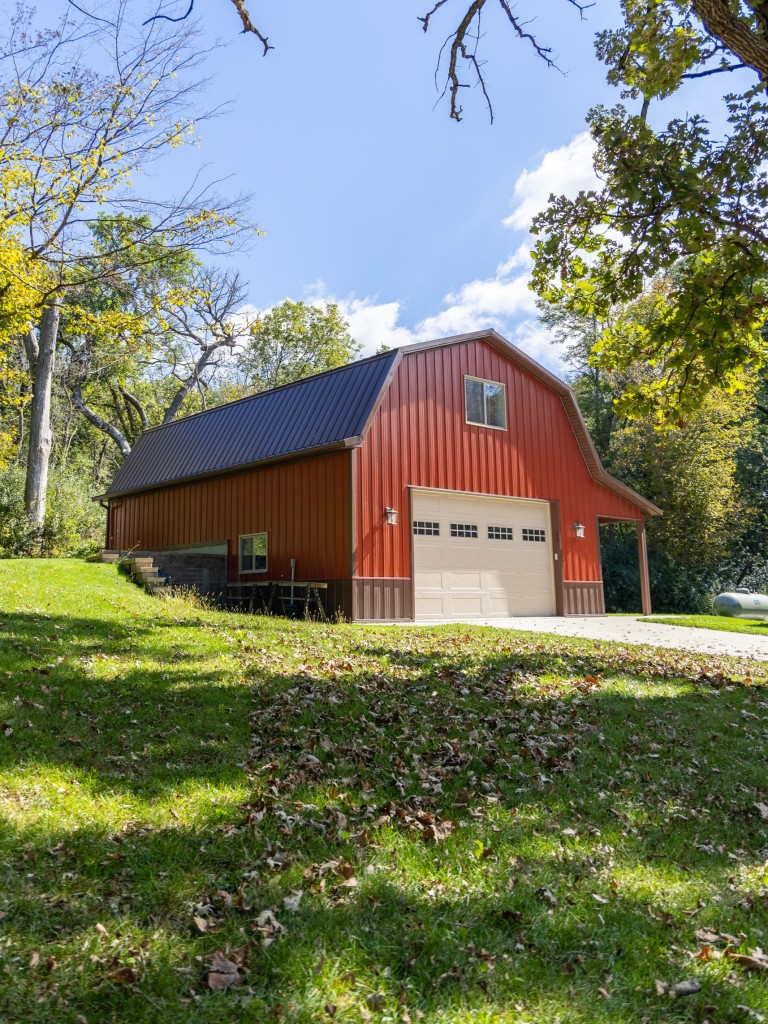 30′ x 40′ Two-Story Gambrel Garage in Nerstrand, MN 30' x 40' two-story gambrel garage in Nerstrand, Minnesota, with red steel siding, brown roof and trim, and a side porch