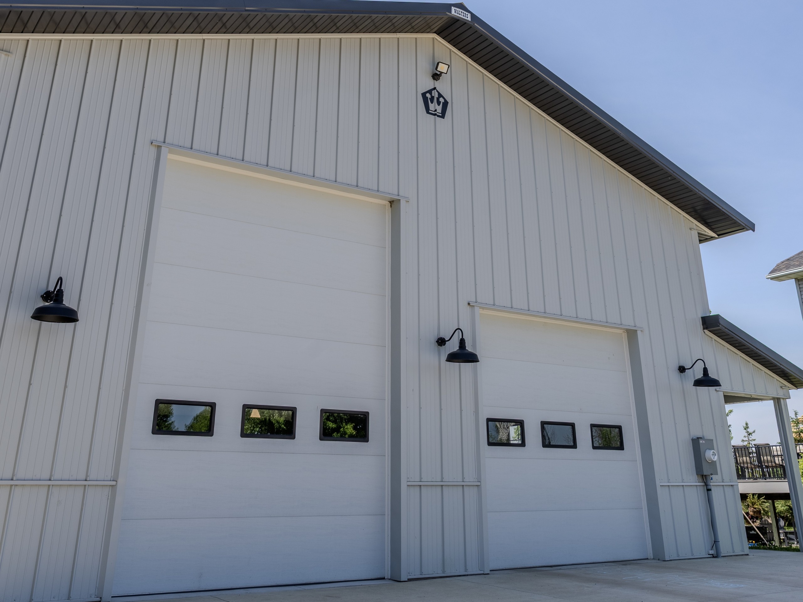 Close-up of 10x14 and 10x10 pole barn garage doors with windows and black gooseneck exterior lights