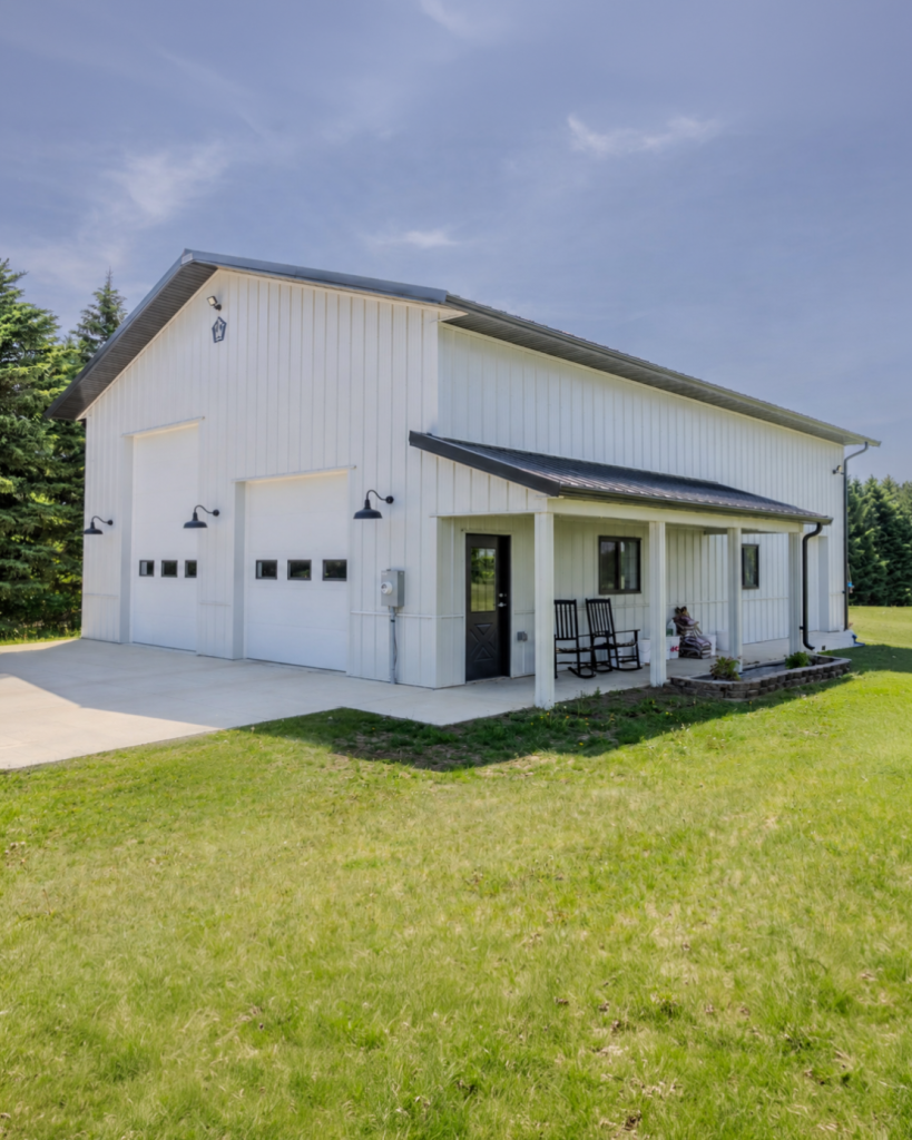 36x50 pole barn garage in Jordan, Minnesota with white steel siding, dark roof, covered porch and multiple overhead doors